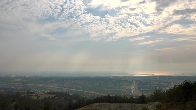 Lebanon Mediterranean coastline timelapse shows drifting clouds, misty water, sunlit horizon.