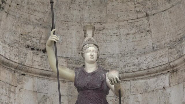 Marble warrior woman statue amid European monument niche, historic architectural heritage.