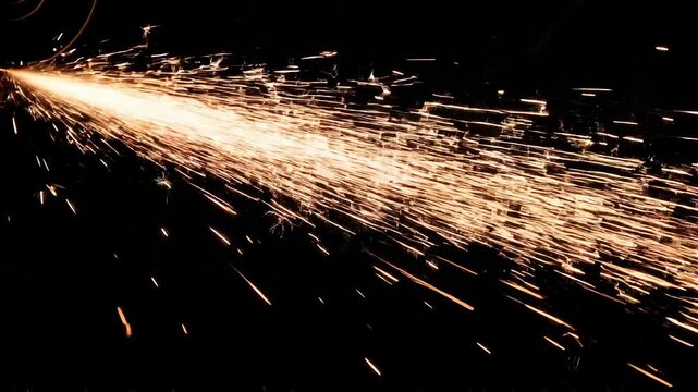 Sparks from Grinding Metal Flying in a Tight Stream, Highlighting Heavy Industry and Manufacturing Power