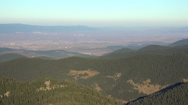 Aerial panoramic view settlements on flat plains below forested hills in Bolu Turkiye.