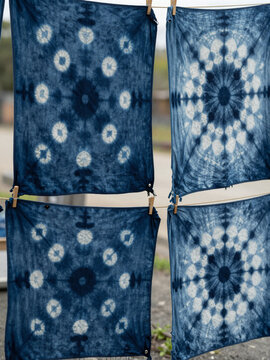 Indigo dyed cotton panels with soft resist patterns hung to dry