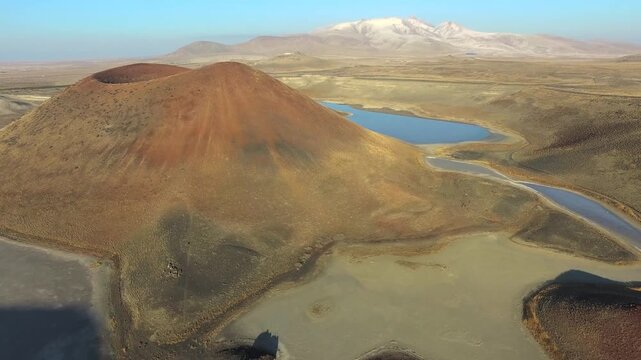Konya Turkey volcanic crater lake sits inside a barren caldera with tuff ring cone.