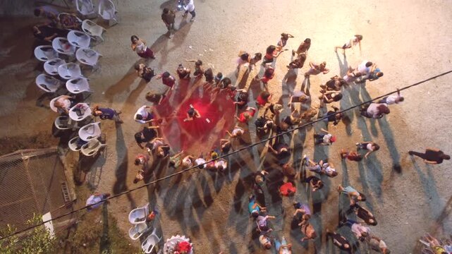 Singer dances at village wedding as guests throw money during lively traditional night celebration.