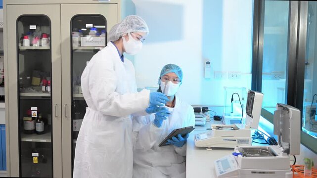 Scientist team meeting and writing analysis results in the laboratory study and analyze scientific sample