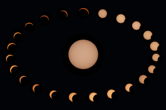Aerial view of a composite sequence showing the progression of a solar eclipse against a dark sky in Mulhouse, Grand Est, France.