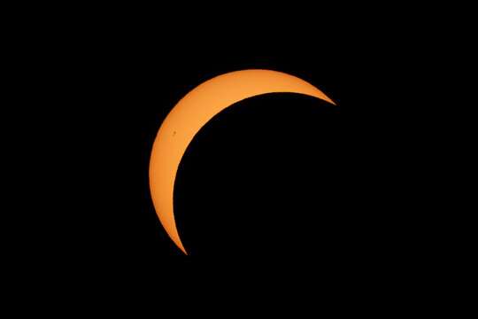 Aerial view of a partial solar eclipse showing the moon obscuring part of the sun against a dark sky Mulhouse, Grand Est, France.