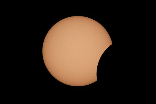 Aerial view of a partial solar eclipse with the moon obscuring part of the sun against a dark sky in Mulhouse, Grand Est, France.