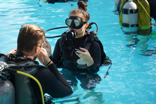 Professional scuba diver instructs the novice how to use the equipment before dive
