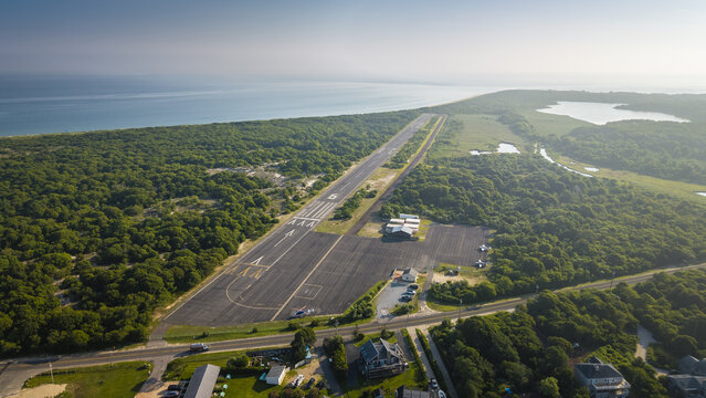 Aerial view of Montauk Airport surrounded by dense forest and coastal landscape in Montauk, New York, United States.