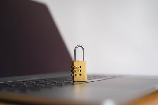 Open combination padlock on laptop keyboard symbolizes cybersecurity, data protection and digital privacy, with copy space for online security, network safety, access control and secure technology.