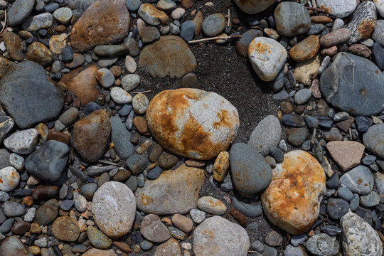 sand and gravel shoal along the shoreline of a shallow river on a sunny day, close-up and soft focus
