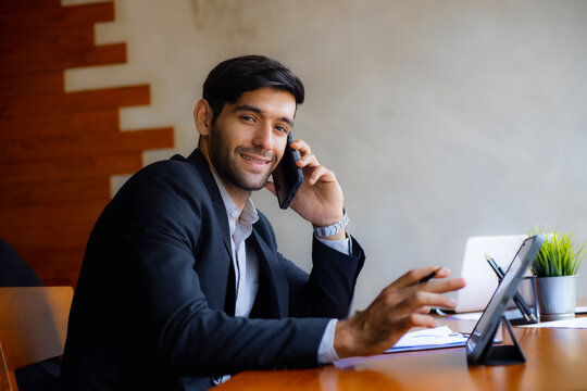 Businessman using smartphone at office desk working on mobile communication