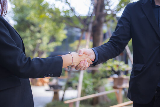 Business partners shaking hands outdoors after successful agreement