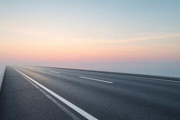 Fototapeta premium Empty asphalt highway stretches towards horizon under pastel sunset sky. Long straight road leads into distance with soft pink, blue colors. Minimalist landscape shows endless path for travel,