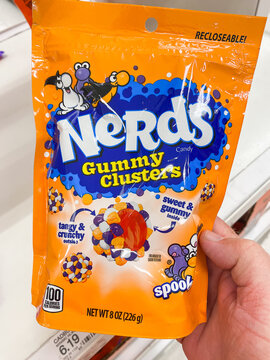 A hand holding an orange bag of Nerds Gummy Clusters Spooky candy in a store - August 8. 2026, Portland Oregon, USA