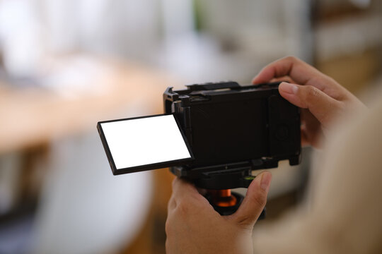 Digital camera with a blank display screen held for a photography mockup.