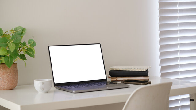 Blank laptop screen displayed on a minimal home office desk for a digital mockup.