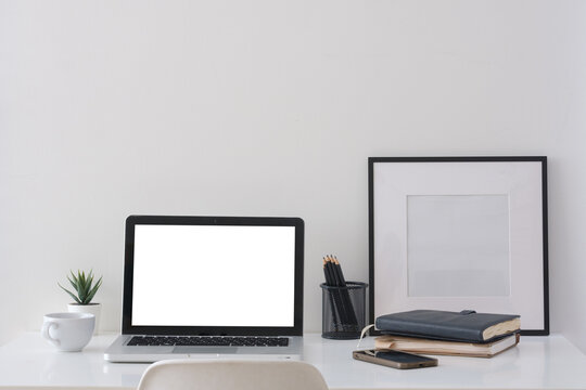 Blank laptop screen displayed on a minimal home office desk for a digital mockup.