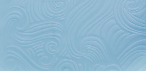 Fototapeta premium Minimalist light blue textured background featuring elegant embossed swirling lines and wave patterns. Copy space 