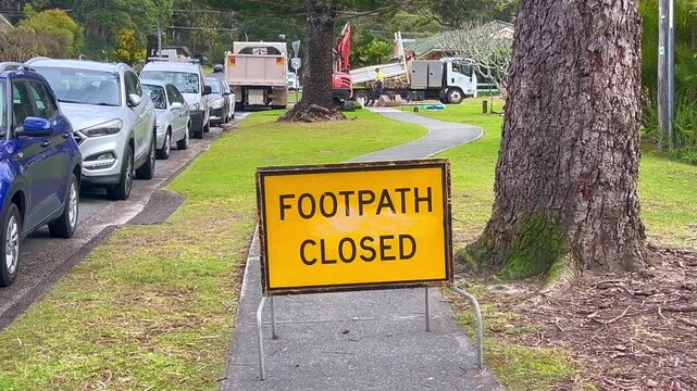 Footpath closed on city street . Urban detour: A temporary barrier closes off a city footpath, redirecting pedestrians around active construction or maintenance work