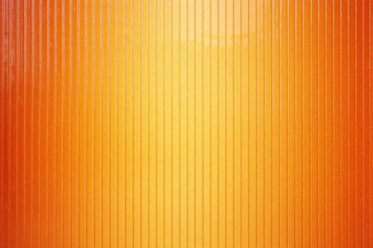 Orange and yellow gradient of ribbed polycarbonate material. This textured surface offers a smooth plastic sheet with vertical lines. It is a bright backdrop.