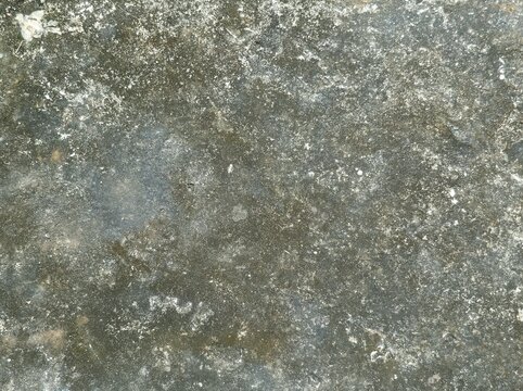 old concrete wall,Weathered stone surface with muted gray, brown, and white tones. Texture shows erosion, moss, and mineral deposits over time. Natural patina suggests age, outdoor exposure
