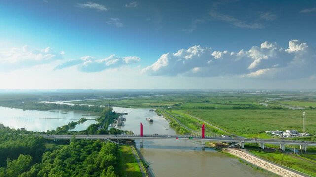 Hefei Binhu Nanfei River Bridge Aerial: Red Cable-stayed Bridge Spanning Emerald Waters and Lush Wetlands