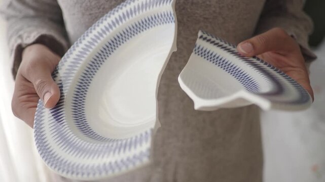 Holding a broken plate with a blue pattern