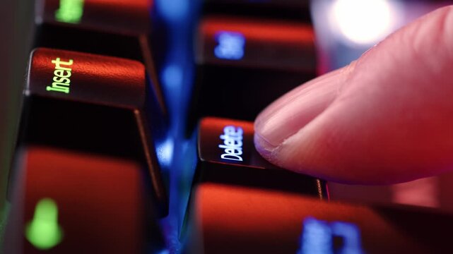Human finger is clicking on the DeleteLock button on the computer keyboard, close up view. The finger presses Delete on the keyboard key, macro shot. Loop footage.