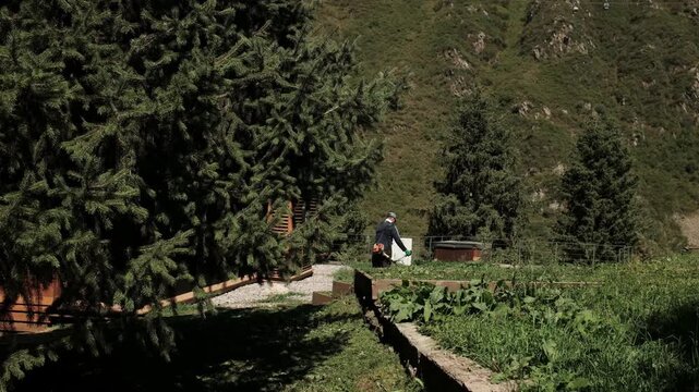 A professional grounds maintenance worker operating a lawn mower in a green outdoor area. The footage illustrates landscaping, gardening, grass cutting and routine property maintenance. 