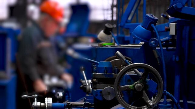 Industrial machine with worker in background.