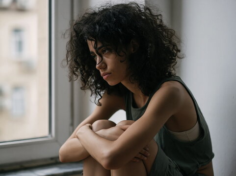 Melancholic Adult Woman Contemplating Life's Challenges in an Urban Caf&eacute;, Conveying Depth of Emotion and Solitude Amidst Soft Ambient Lighting