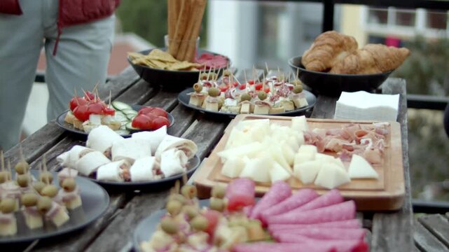 Variety of appetizers and snacks on a rustic wooden outdoor table