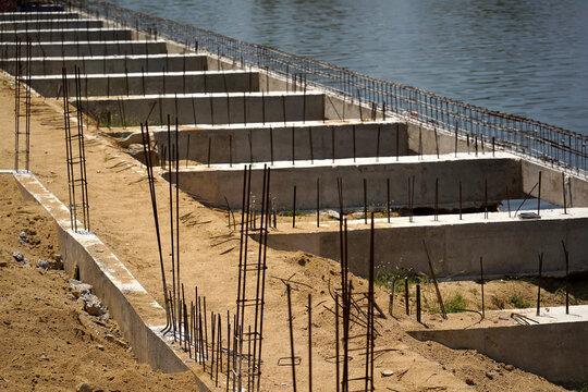Building process city levee. Exposed foundation rebar grid at site, standing formwork and concrete footings