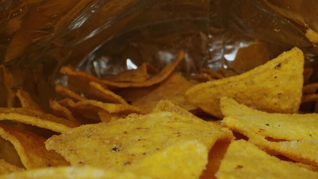 Macro view of crunchy corn tortilla chips inside a foil snack bag