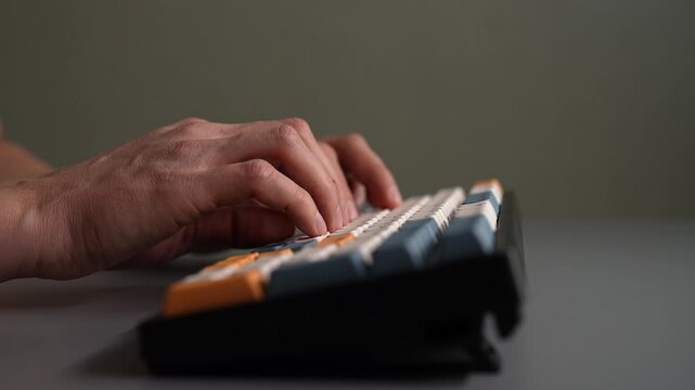 Side view of male hands typing on mechanical computer keyboard. Concept of rapid finger movements for efficient data entry, programming, writing, online communication in modern workspace, slow motion.