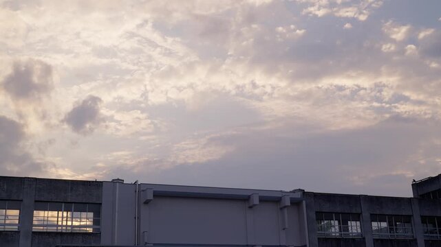 ノスタルジックな校舎と夕焼け空のグラデーションが美しい流れる雲の早送り映像