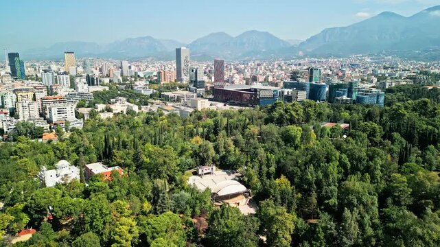 Albania, Tirana 06 09 2025: Dolly drone video over Grand Park revealing open-air amphitheater with Arena Kombetare, Marriott, Archaeological Museum and Downtown One in background.