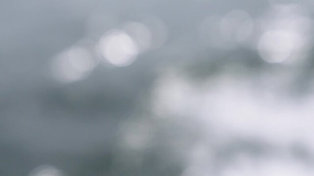 Abstract soft bokeh background featuring light gray and white circles of light. Minimalist blurred texture for professional web design, presentations, and creative projects. Elegant, calm style.