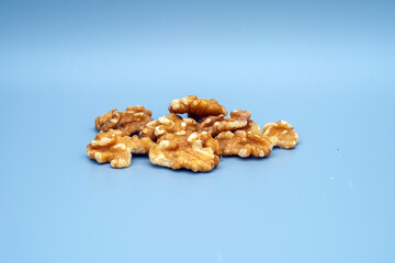 Fototapeta premium Walnuts are arranged on a blue background showing their natural texture and color
