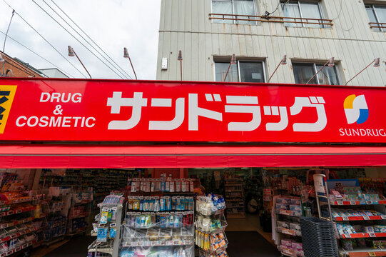 SUGINAMI-KU, TOKYO, JAPAN - AUGUST 15, 2026: Red brand signboard for SUNDRUG pharmacy chain store in Suginami-ku, Tokyo.