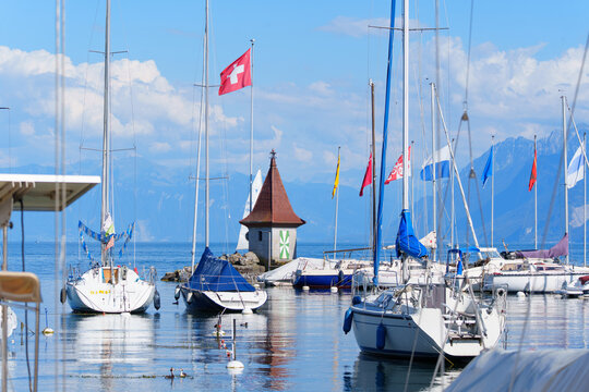 Morges, Switzerland - August 6, 2026: Scenic Marina of Morges with Sailboats and Swiss Flag on Lake Geneva
