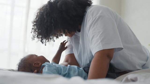 African american woman playing with adopted baby, enjoy happy family moments. Tender, love and oxytocin, young black lady enjoying calm day with son or daughter in cozy home interior, single mother