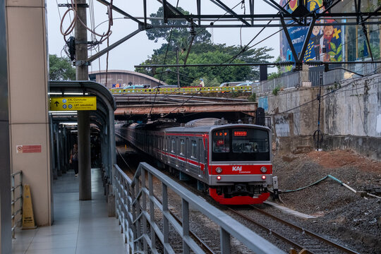 Jakarta, Indonesia - August 9, 2026: KAI Commuter JR 205 Series train departs beneath the Sudirman Street bridge.