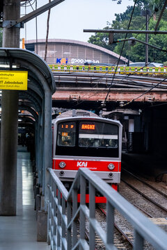 Jakarta, Indonesia - August 9, 2026: KAI Commuter JR 205 Series train departs beneath the Sudirman Street bridge.