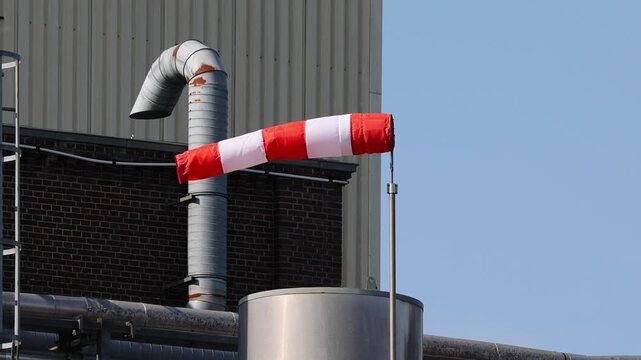 Windsock blowing on a windy day at industrial plant