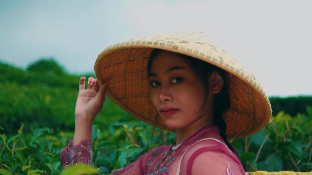 Close-up Portrait of Asian Woman in Traditional Hat at Tea Farm