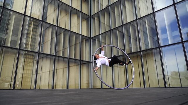 Dynamic and vibrant performance of a Cyr Wheel within urban architecture. Concept of expression, freedom, passion and potential