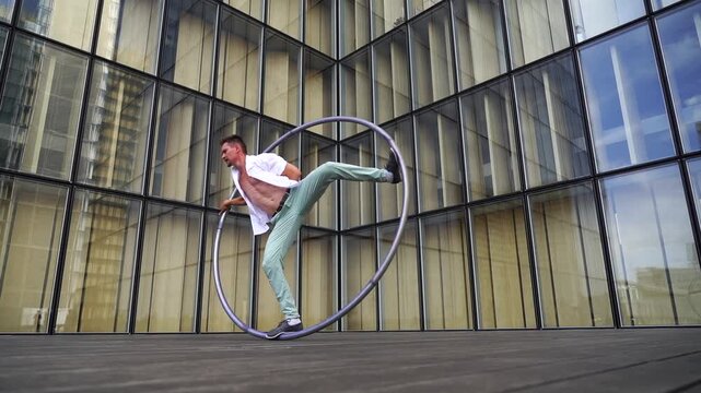 Dynamic and vibrant performance of a Cyr Wheel within urban architecture. Concept of originality, creativity and outstanding