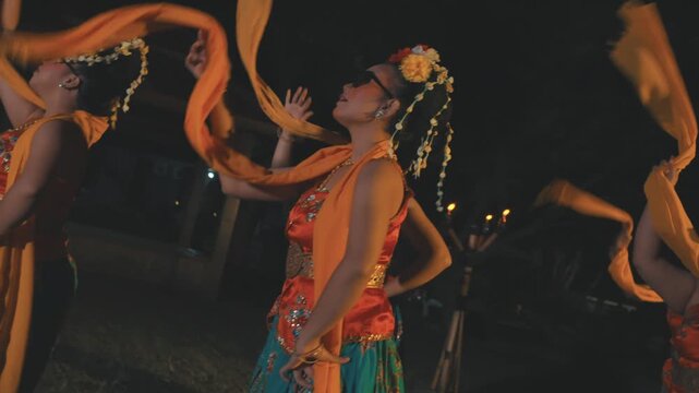 Indonesian Dancers in Traditional Costumes Turning and Posing at Night